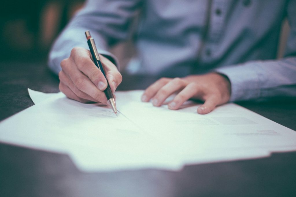 Documenti contrattuali esaminati su un tavolo di lavoro