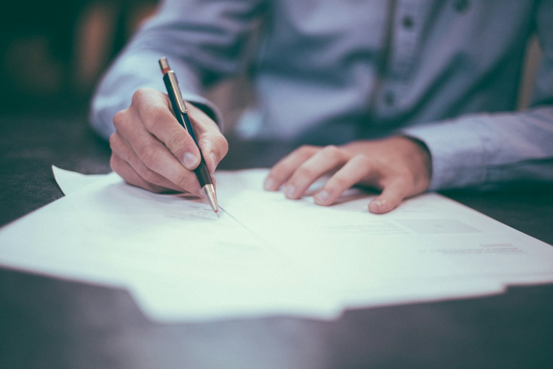 Documenti contrattuali esaminati su un tavolo di lavoro
