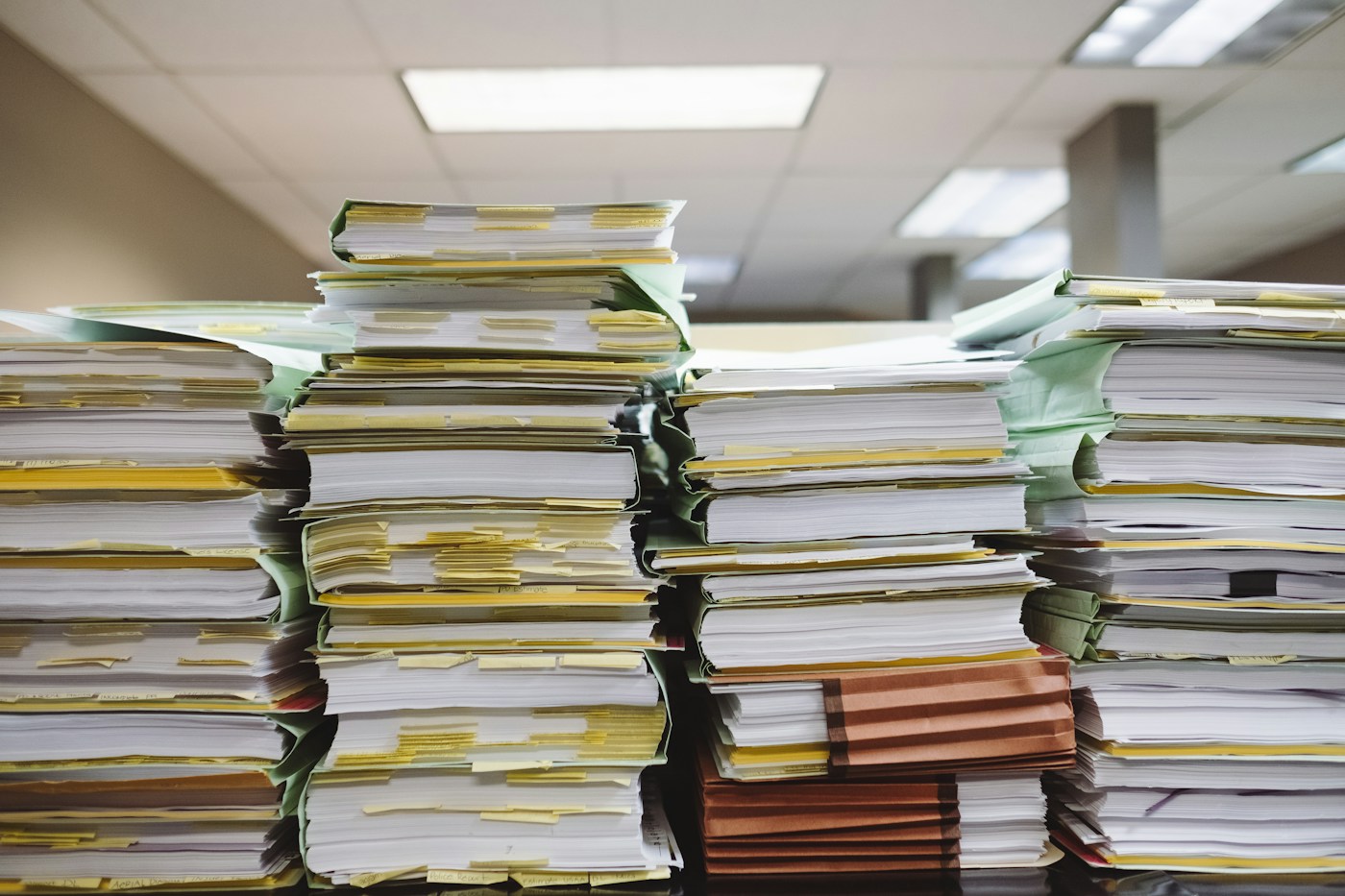 Pile di documenti cartacei e cartelle per l’archivio