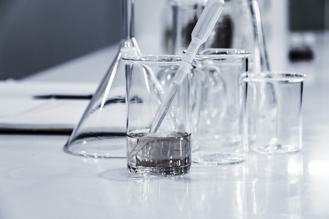 Becher e altri recipienti di vetro sul piano di un laboratorio